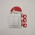 Decoratiune de Craciun inedita pentru intrerupator sau priza, avand sloganul Ho Ho Ho si Caciula lui Mos Craciun, culori rosu glitter si alb, aspect unic, 125x105x5 mm
